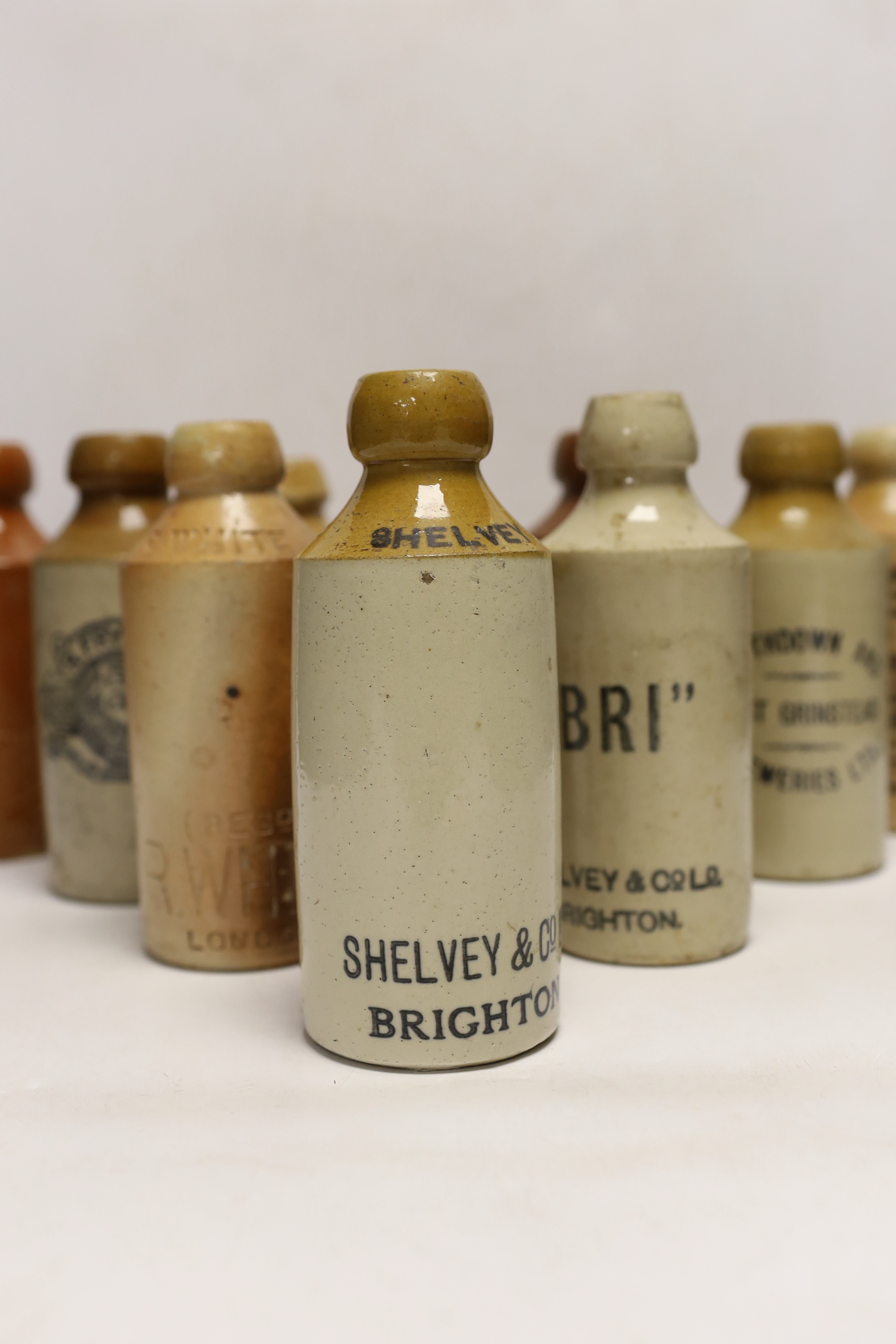 Early 20th century stoneware ginger beer bottles, two of Brighton, one of London, one of East Grinstead and four others